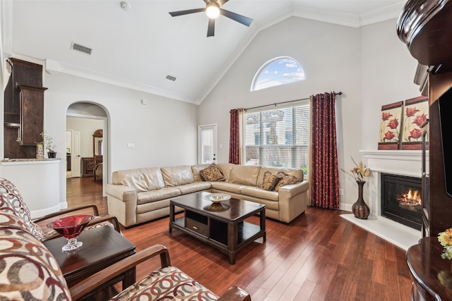 living area featuring a glass covered fireplace, visible vents, wood finished floors, and arched walkways