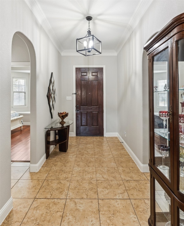 entrance foyer with light tile patterned flooring, arched walkways, and ornamental molding