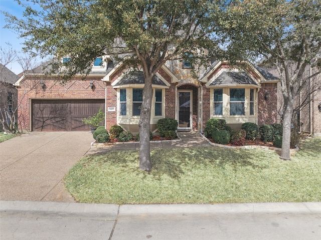 view of front of house featuring brick siding, a garage, driveway, and a front yard