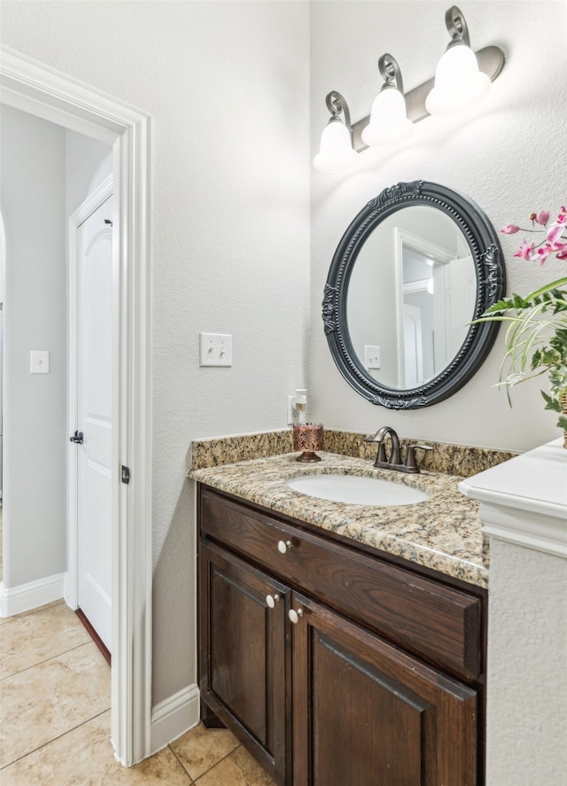 bathroom with tile patterned floors, baseboards, and vanity