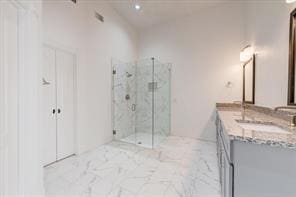 full bathroom with marble finish floor, a marble finish shower, and vanity