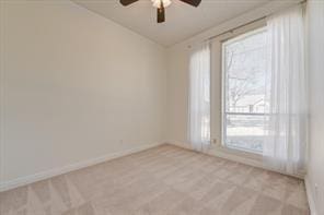 empty room featuring lofted ceiling, ceiling fan, and baseboards