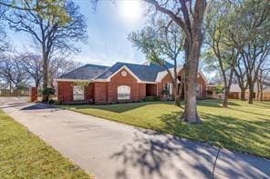 ranch-style home featuring aphalt driveway and a front yard