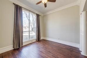 spare room featuring ceiling fan, baseboards, crown molding, and wood finished floors