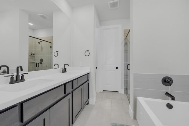 full bathroom with visible vents, a sink, a shower stall, and a freestanding bath