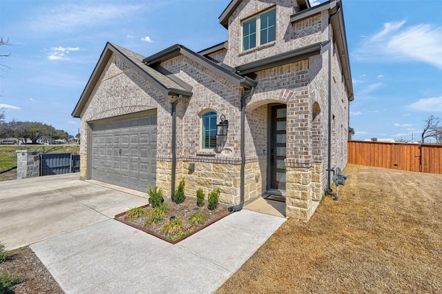 french provincial home with a garage, concrete driveway, and fence