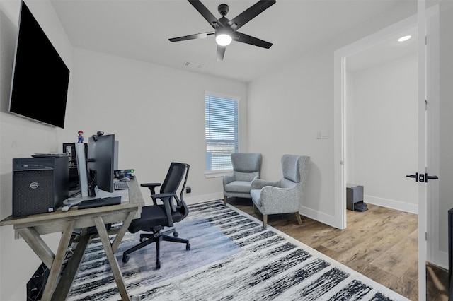 office area with baseboards, visible vents, ceiling fan, and wood finished floors