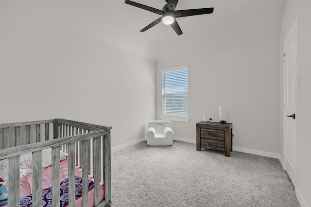 carpeted bedroom with a nursery area, baseboards, and a ceiling fan