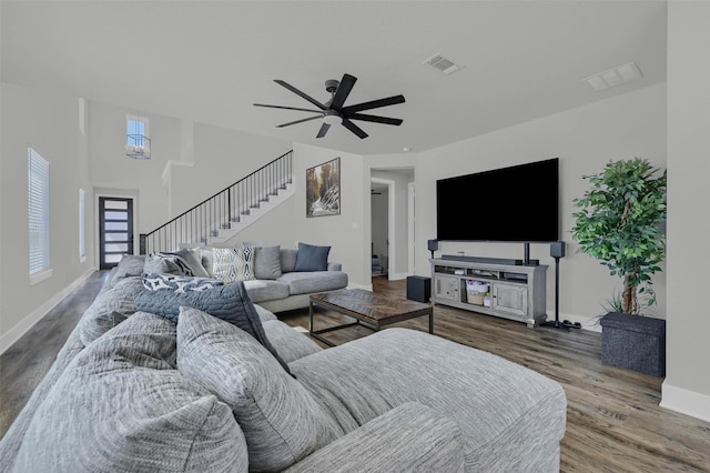 living area featuring visible vents, ceiling fan, wood finished floors, baseboards, and stairs