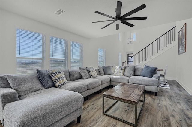 living area with wood finished floors, visible vents, plenty of natural light, and stairs