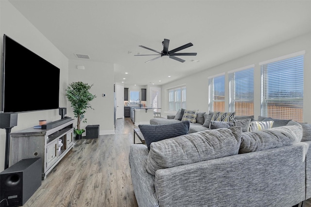 living area featuring recessed lighting, visible vents, light wood-style flooring, a ceiling fan, and baseboards