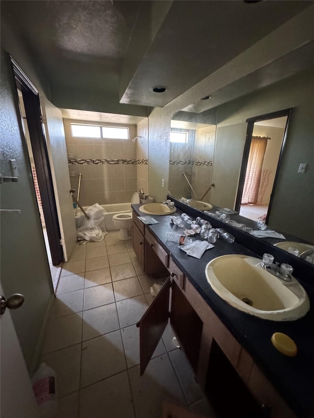 full bath featuring double vanity, a sink, toilet, and tile patterned floors