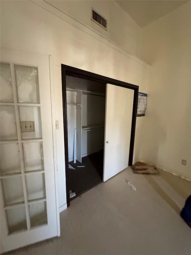 unfurnished bedroom with concrete floors, a closet, and visible vents