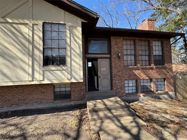 view of front of house with brick siding and a chimney