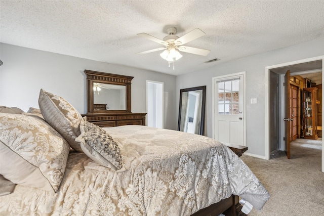 carpeted bedroom with visible vents, ceiling fan, a textured ceiling, and baseboards