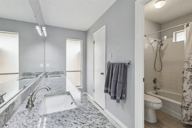 bathroom with a textured ceiling, a sink, and toilet