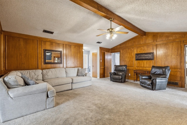 carpeted living area with visible vents, vaulted ceiling with beams, wooden walls, and a textured ceiling