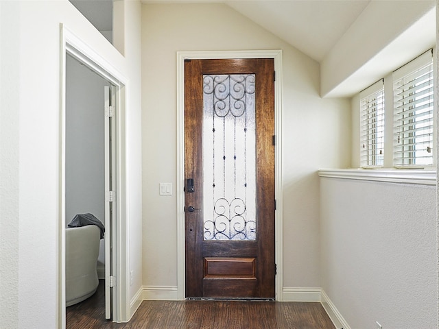 foyer entrance with vaulted ceiling, dark wood-style flooring, and baseboards