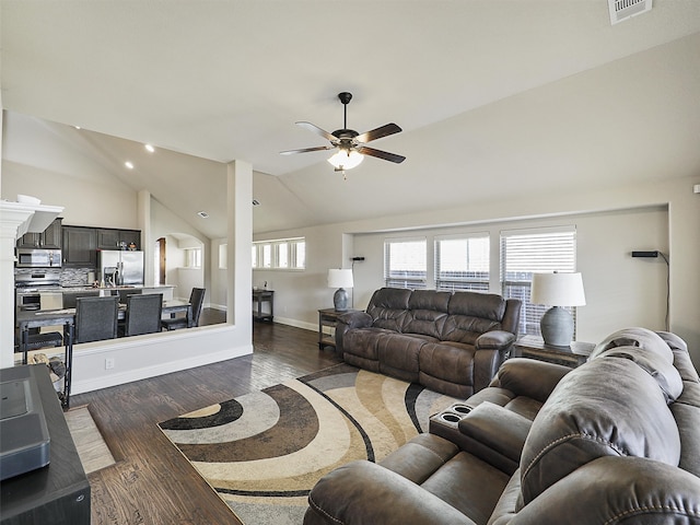 living area with dark wood-style floors, lofted ceiling, visible vents, and baseboards