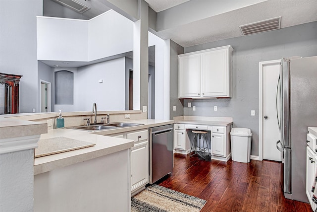 kitchen featuring visible vents, dark wood-style floors, stainless steel appliances, light countertops, and a sink