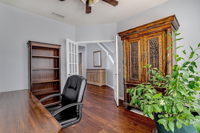 home office featuring ceiling fan, a textured ceiling, dark wood-style flooring, visible vents, and baseboards