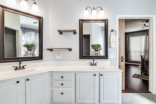 bathroom with a sink, a textured ceiling, and double vanity