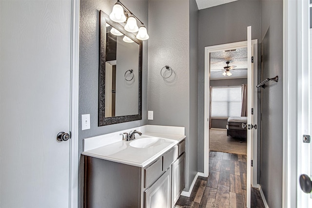 bathroom with baseboards, ensuite bath, wood finished floors, a textured ceiling, and vanity