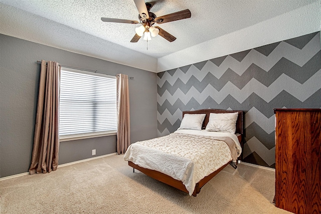 bedroom with a textured ceiling, an accent wall, and wallpapered walls