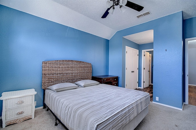 bedroom featuring a textured ceiling, carpet floors, visible vents, and baseboards