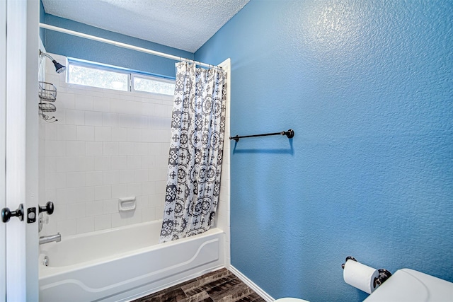 full bath featuring a textured ceiling, a textured wall, toilet, wood finished floors, and shower / tub combo with curtain