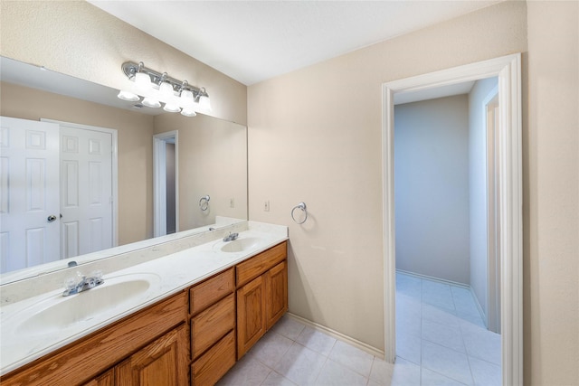 full bath with double vanity, baseboards, a sink, and tile patterned floors