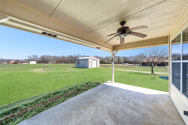 view of patio / terrace featuring a storage unit, a ceiling fan, and an outbuilding