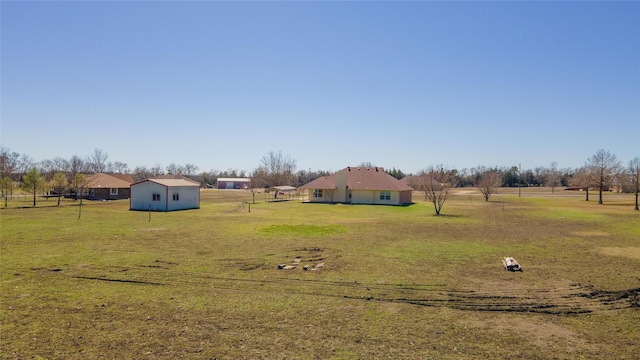 view of yard with an outbuilding and a rural view