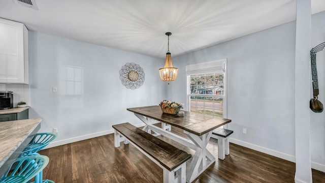 dining room with dark wood-style floors, visible vents, baseboards, and an inviting chandelier