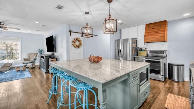 kitchen featuring dark wood-style floors, visible vents, appliances with stainless steel finishes, ceiling fan with notable chandelier, and open floor plan