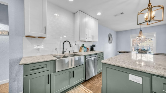 kitchen featuring visible vents, green cabinets, stainless steel dishwasher, a notable chandelier, and a sink