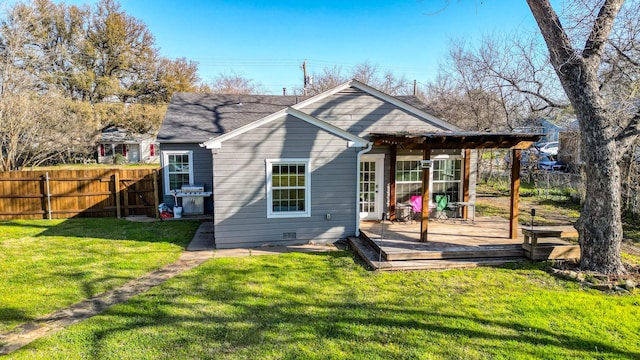 back of house featuring fence, a lawn, and a wooden deck