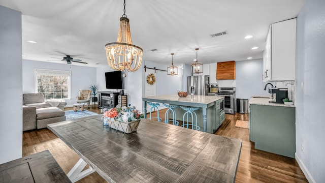 dining room with visible vents, baseboards, recessed lighting, dark wood-style flooring, and ceiling fan with notable chandelier