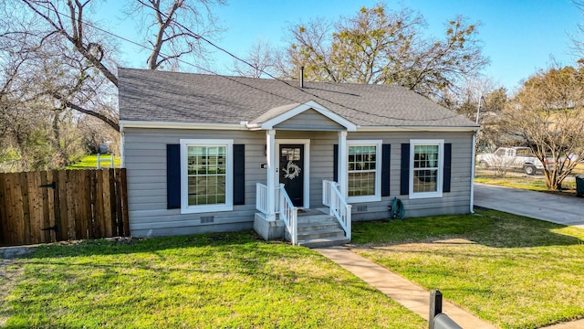 bungalow-style house with a front yard, fence, and roof with shingles