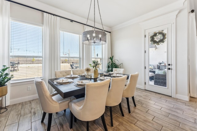 dining room featuring ornamental molding, wood tiled floor, and baseboards