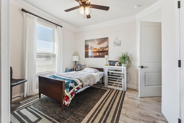 bedroom featuring ornamental molding, baseboards, light wood finished floors, and a ceiling fan