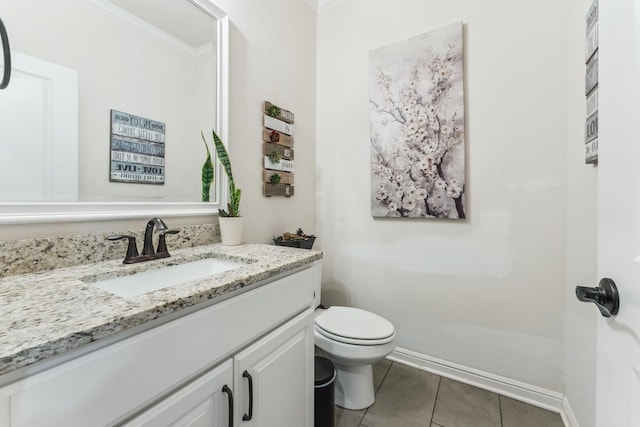 bathroom with baseboards, toilet, ornamental molding, tile patterned flooring, and vanity