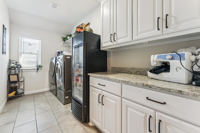 laundry room featuring cabinet space, visible vents, baseboards, independent washer and dryer, and light tile patterned flooring