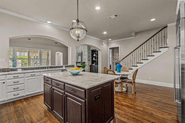 kitchen featuring dark brown cabinets, visible vents, white cabinets, and dark wood finished floors