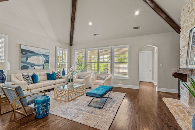 living area with wood finished floors, visible vents, high vaulted ceiling, beamed ceiling, and a wealth of natural light