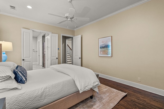 bedroom featuring visible vents, wood finished floors, baseboards, and ornamental molding