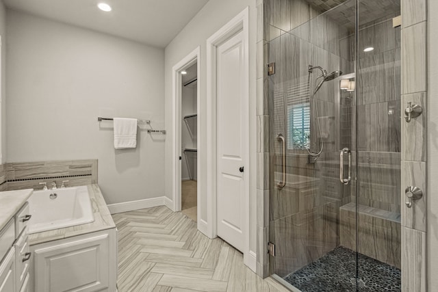 full bathroom with baseboards, a spacious closet, a stall shower, and vanity