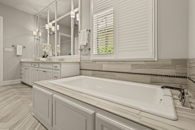 bathroom featuring vanity, a garden tub, and baseboards