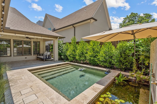 view of swimming pool featuring a hot tub and ceiling fan