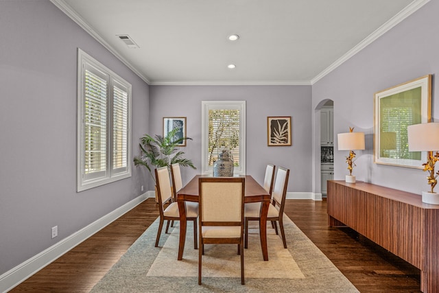 dining area featuring visible vents, baseboards, ornamental molding, and dark wood-style flooring